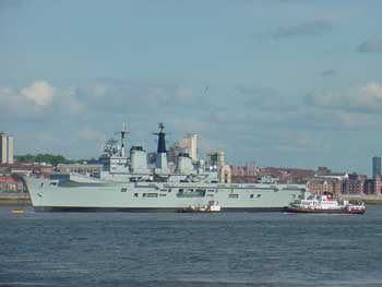 ferry across the mersey sailing alongside the warship